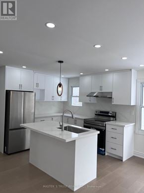 Ramara apartment for rent - A modern kitchen with white cabinets and appliances.