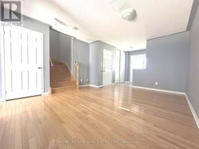 Richmond Hill (Oak Ridges) townhouse for rent - A room with wooden flooring and a staircase in the background.