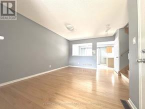 Richmond Hill (Oak Ridges) townhouse for rent - A spacious room with wooden flooring and a door on the right.