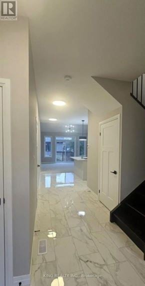 Cambridge townhouse for rent - A hallway with marble flooring and white walls.