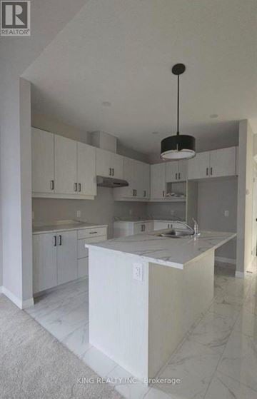 Cambridge townhouse for rent - A kitchen with white cabinets and a marble floor.