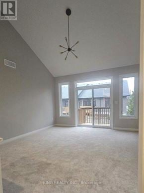 Cambridge townhouse for rent - A spacious room with a chandelier and a view of a balcony through the sliding glass doors.