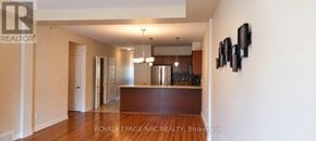 St. Catharines (Oakdale) townhouse for rent - A spacious room with a kitchen area in the background.
