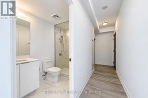 Toronto (Newtonbrook East) condo for rent - A white bathroom with a toilet, sink, and mirror.
