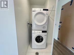 Vaughan (Concord) condo for rent - A white front loading washing machine in a small laundry room.