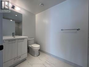 Vaughan (Concord) condo for rent - A white bathroom with a toilet, sink, and a mirror.