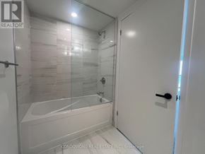 Vaughan (Concord) condo for rent - A white bathroom with a glass shower door and a bathtub.