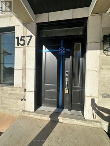 Oakville (Go Glenorchy) townhouse for rent - The door number 157 is black and has a blue ribbon tied around it.