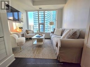 Toronto (Waterfront Communities) condo for rent - A living room with a large window and a view of a city skyline.