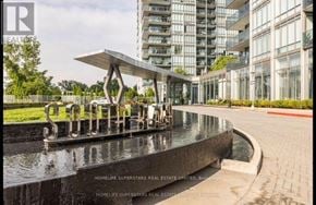 Toronto (Mimico) condo for rent - A fountain in front of a building with the name of the real estate company on it.