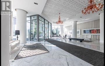 Toronto (Mimico) condo for rent - A large, open living space with a chandelier and a long hallway.