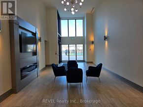 St. Catharines (Oakdale) condo for rent - A living room with a television, chairs, and a large window.