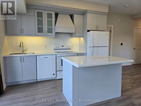 St. Catharines (Oakdale) condo for rent - A white kitchen with a white island and white cabinets.