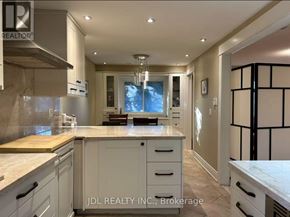 Toronto (Hillcrest Village) apartment for rent - A modern kitchen with white cabinets and a wooden island.