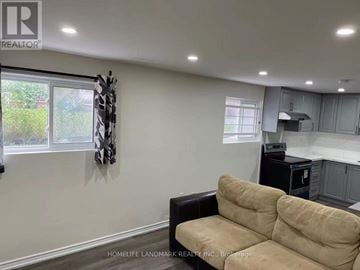 Toronto (Pleasant View) apartment for rent - A living room with a beige couch and a black chair.