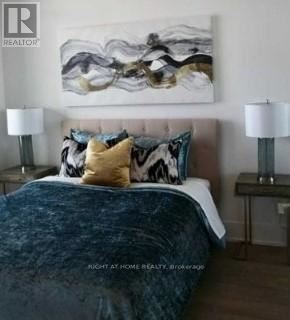 Toronto (Waterfront Communities) condo for rent - A bedroom with a large bed and a painting on the wall.