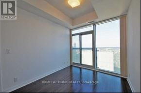 Toronto (Waterfront Communities) condo for rent - A room with a view of the city through a large window.