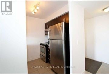 Toronto (Bendale) condo for rent - A kitchen with a stainless steel refrigerator and microwave.