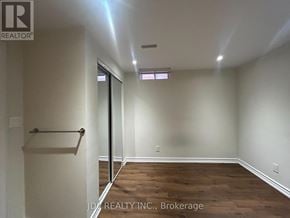 Markham (Buttonville) apartment for rent - A room with wooden floors and white walls, with a door leading to another room.