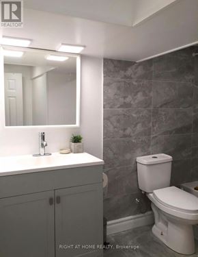 Brock (Beaverton) apartment for rent - A bathroom with a toilet, sink, and mirror.