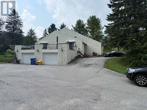 Whitchurch-Stouffville apartment for rent - A white building with a garage door and a car parked in front.