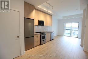 Oakville (Jm Joshua Meadows) condo for rent - A kitchen with wooden cabinets and a refrigerator.