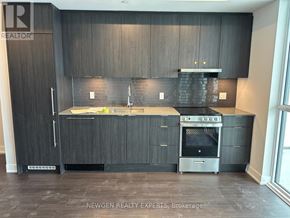 Mississauga (City Centre) condo for rent - A modern kitchen with dark wood cabinets and stainless steel appliances.