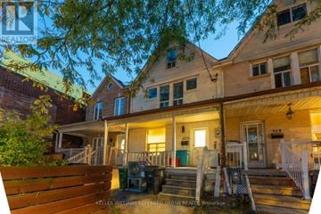 Toronto (Dovercourt-Wallace Emerson-Junction) triplex for rent - A house with a porch and a tree in front of it.