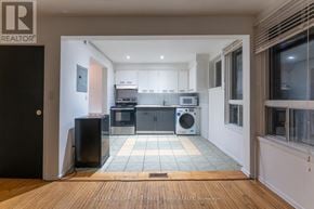 Toronto (Dovercourt-Wallace Emerson-Junction) triplex for rent - A modern kitchen with a black fridge and a black speaker.