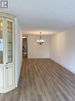 Mississauga (Malton) apartment for rent - A room with wooden flooring and a chandelier hanging from the ceiling.