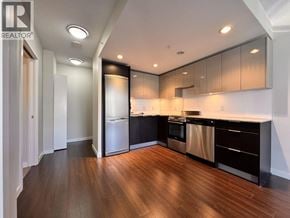 Vancouver apartment for rent - A modern kitchen with dark wood floors and stainless steel appliances.