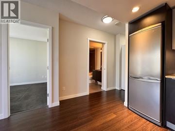 Vancouver apartment for rent - A kitchen area with a refrigerator and a doorway leading to another room.