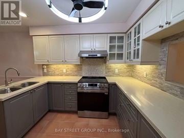 Hamilton (Meadowlands) townhouse for rent - A kitchen with a stove top oven and a fan.