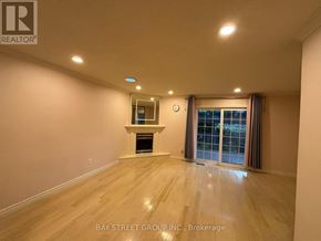 Hamilton (Meadowlands) townhouse for rent - A spacious room with a fireplace and a window with curtains.