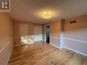 Hamilton (Meadowlands) townhouse for rent - A room with wooden floors and a light fixture on the ceiling.