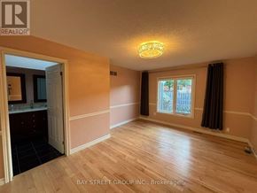 Hamilton (Meadowlands) townhouse for rent - A room with wooden floors and a window with curtains.