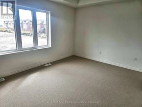 Hamilton (Stoney Creek Mountain) apartment for rent - A room with a carpeted floor and a window overlooking a yard.