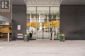 Toronto (Waterfront Communities) condo for rent - The entrance to a building with a glass door and a number 65 on it.