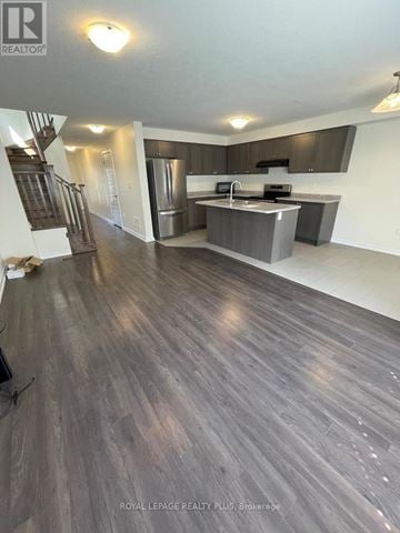 Hamilton (Stoney Creek Mountain) townhouse for rent - A spacious kitchen with dark wood flooring and modern appliances.