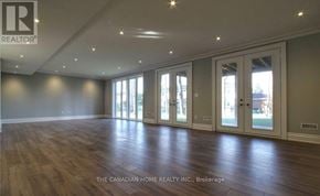 Toronto (Agincourt South-Malvern West) apartment for rent - A spacious room with wooden floors and large windows.