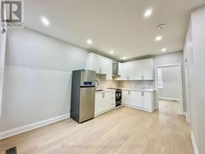 Toronto (Weston-Pellam Park) duplex for rent - A kitchen with white cabinets and a stainless steel refrigerator.