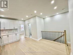 Toronto (Weston-Pellam Park) duplex for rent - A spacious room with wooden flooring and white walls.