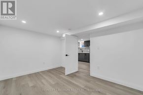 Toronto (Kennedy Park) apartment for rent - A white room with wooden flooring and a doorway leading to another room.