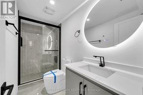 Toronto (Kennedy Park) apartment for rent - A modern bathroom with a white sink and a round mirror.