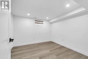 Toronto (Kennedy Park) apartment for rent - A room with white walls and wooden flooring, with a black door handle on the left.
