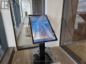 Vaughan (Vellore Village) condo for rent - A digital tablet displaying a building on its screen is placed on a stand in a room.