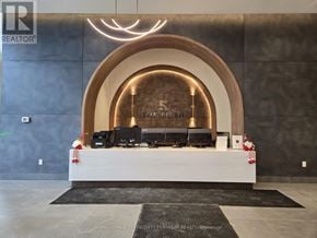 Vaughan (Vellore Village) condo for rent - A reception area with a large desk and a sign that reads "The Fifth".