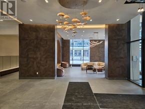 Vaughan (Vellore Village) condo for rent - A lobby with a black carpet and a brown wall.
