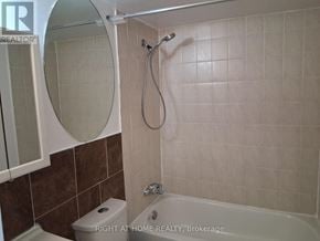 Toronto (Glenfield-Jane Heights) apartment for rent - A bathroom with a toilet, tub, and mirror.