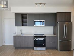 Toronto (Mount Pleasant West) condo for rent - A modern kitchen with a refrigerator, sink, and cabinets.